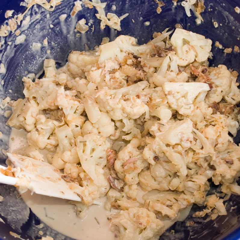 Mixing Cauliflower, Bacon, Caramelized Onions and Cream in a Bowl