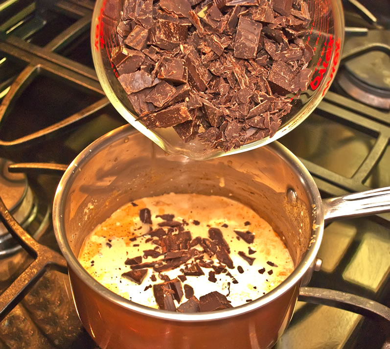 Adding chopped bar chocolate to hot cream
