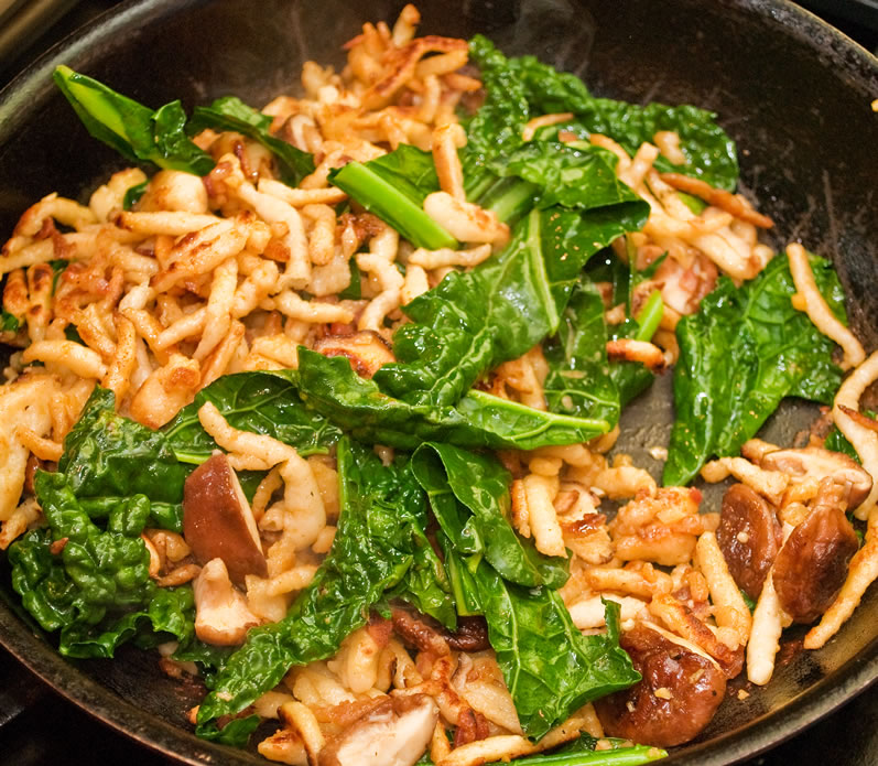 Spaetzel mushrooms and kale in the pan