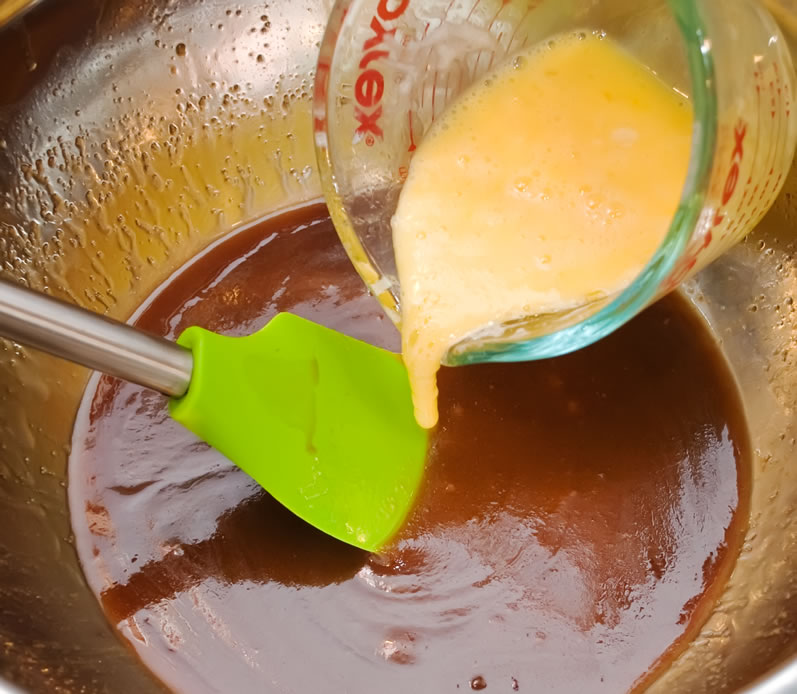 Adding beaten eggs to brown sugar and butter base