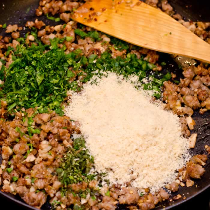 Combining Sauteed Sausage Fresh Herbs Parmesan and Bread Crumbs for Stuffed Mushrooms
